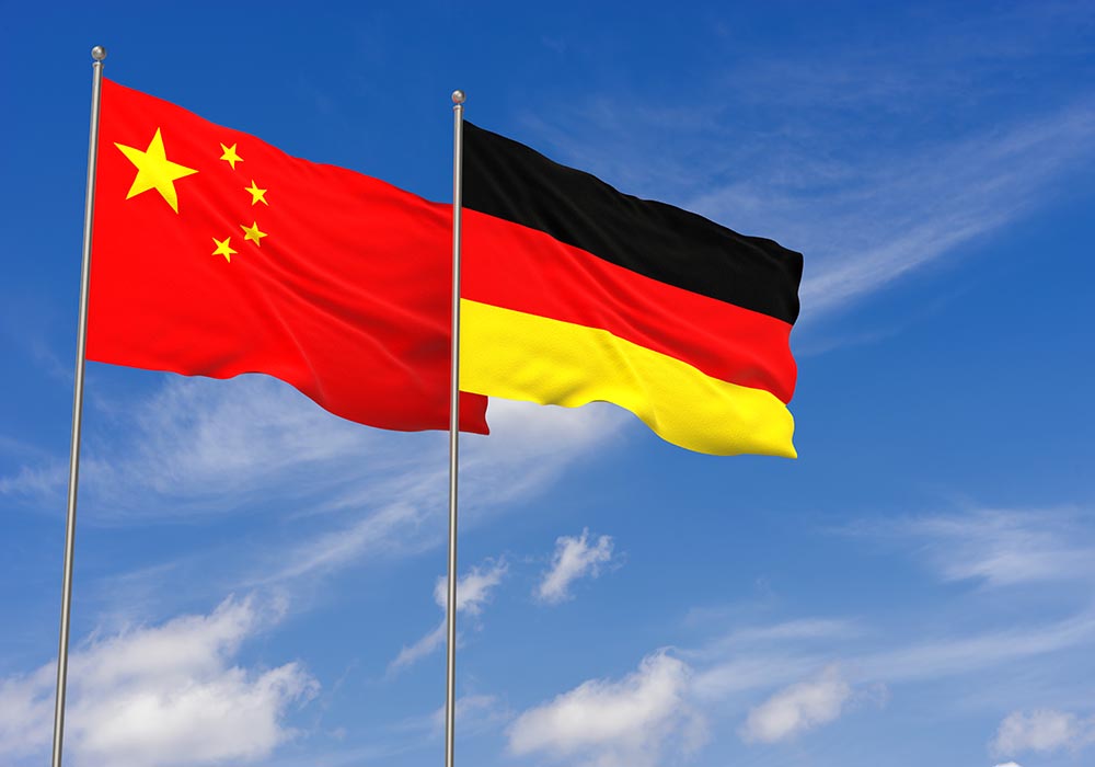 Chinesische und deutsche Flagge vor blauem Himmel
