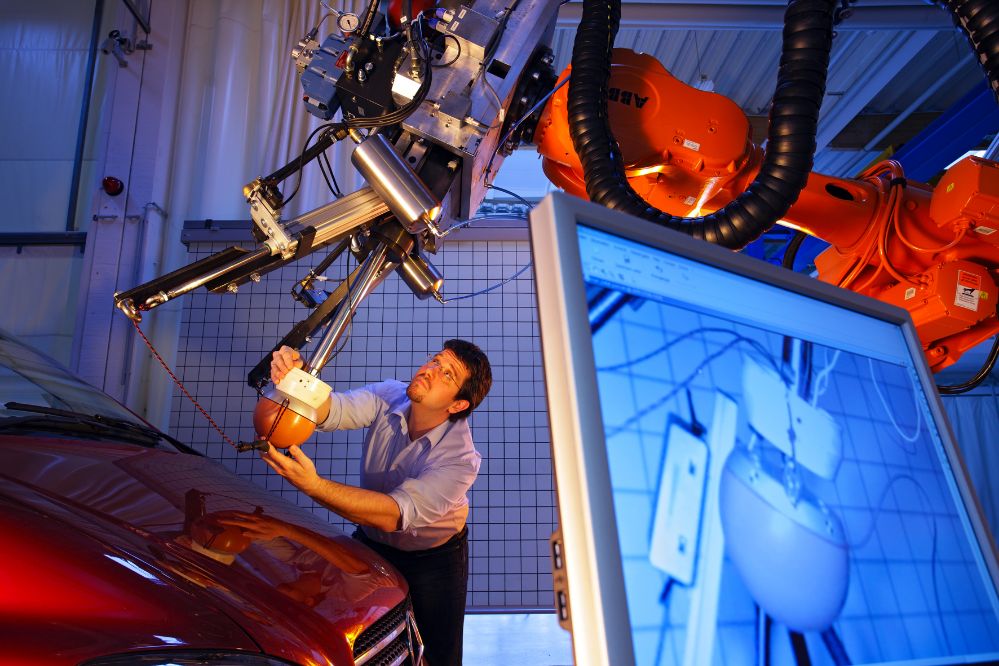 Foto Mann arbeitet mit einem technischen Gerät an einem Auto